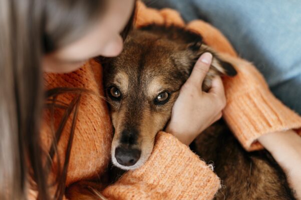Woman holding dog. Grief support.